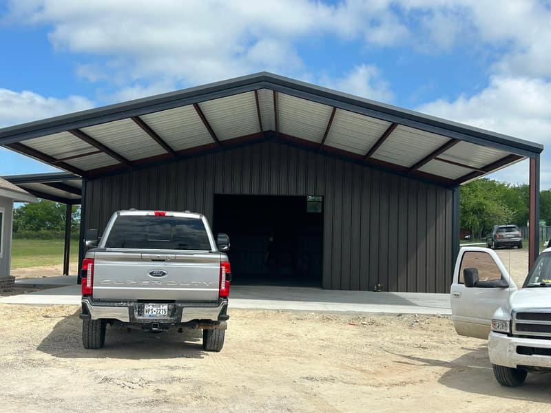 Dark brown open-front metal carport with a silver pickup parked underneath