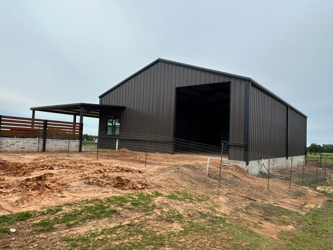 Pipe fencing and pens beside a metal barn